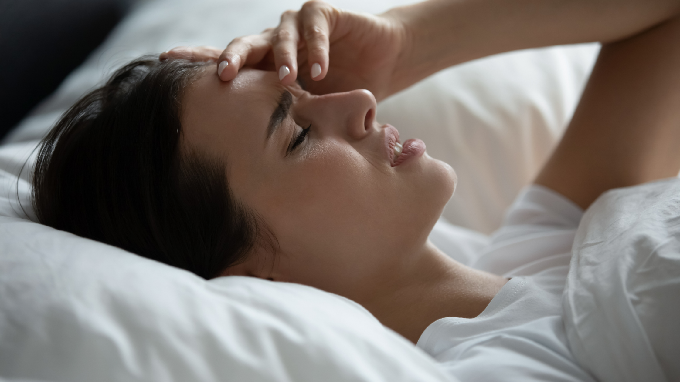woman in bed with chronic migraines